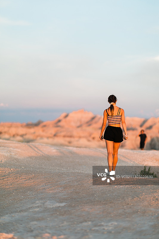 美国南达科塔州Badlands国家公园，一名白人少女在沙漠中行走图片素材