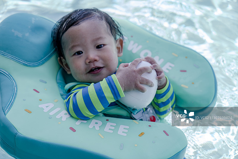 婴儿与玩具鸭在泳池游泳特写图片素材