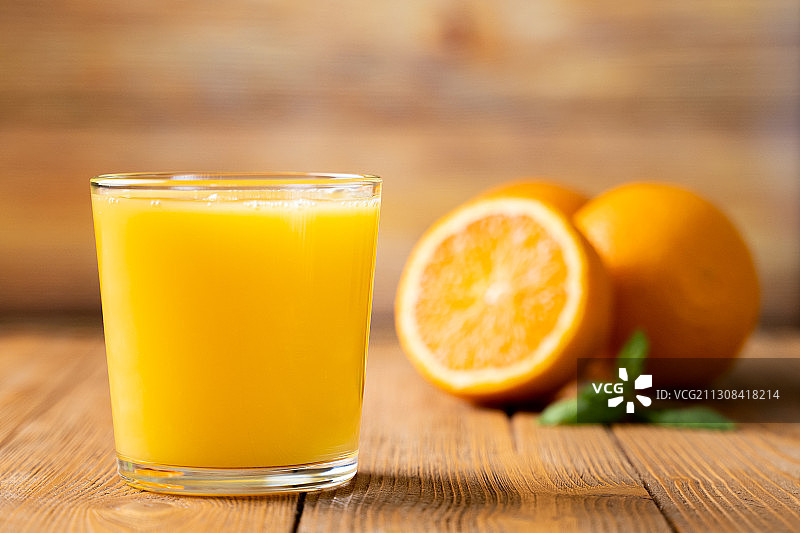 桌子上玻璃杯里的橙汁特写图片素材