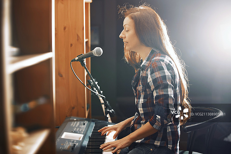 弹奏着键盘钢琴，唱着歌的女人图片素材
