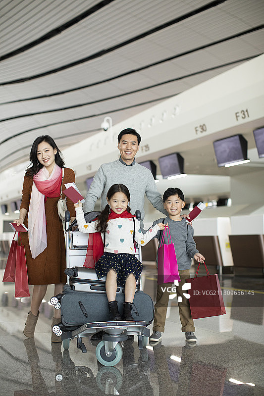 快乐的年轻家庭在机场准备出发去旅行图片素材
