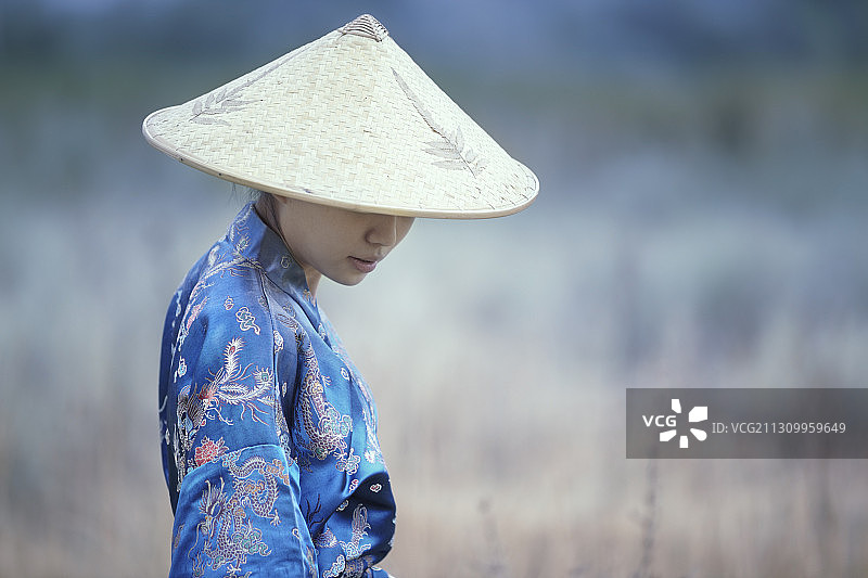 美丽的亚洲女士在传统服装和草帽图片素材