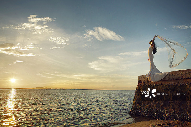 东方新娘站在海边岩石上图片素材