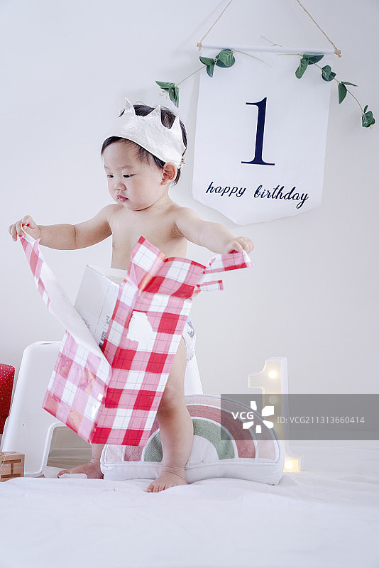 一周岁小寿星快乐打开生日礼盒图片素材