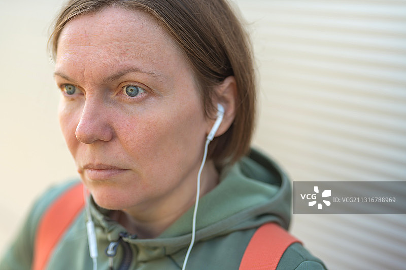 塞尔维亚，城市女性在街上用耳机听音乐图片素材