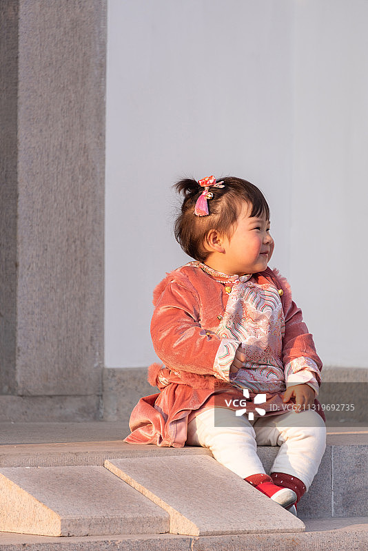 穿着汉服坐在台阶上玩耍的小女孩儿图片素材