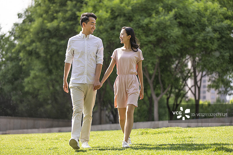 快乐的年轻夫妇在公园散步图片素材