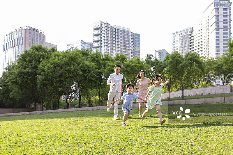 快乐的年轻家庭在公园玩耍图片素材