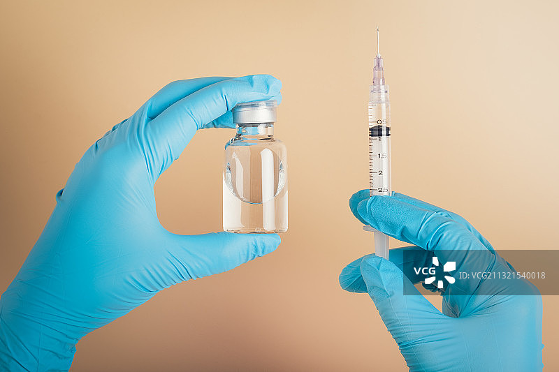 医生拿着一个装有液体疫苗的注射器图片素材