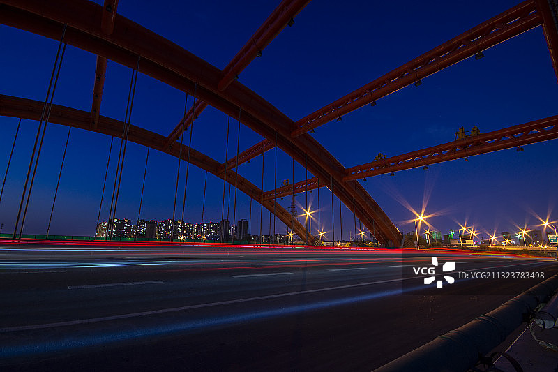 夜晚城市边缘外的一座树立着的钢架公路桥图片素材
