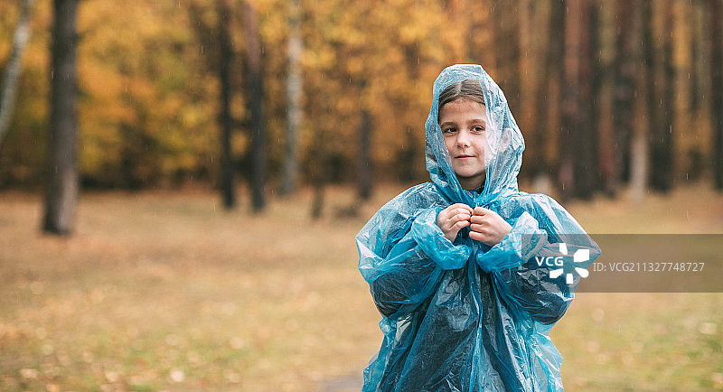 一个女孩在雨中在公园里散步的肖像图片素材