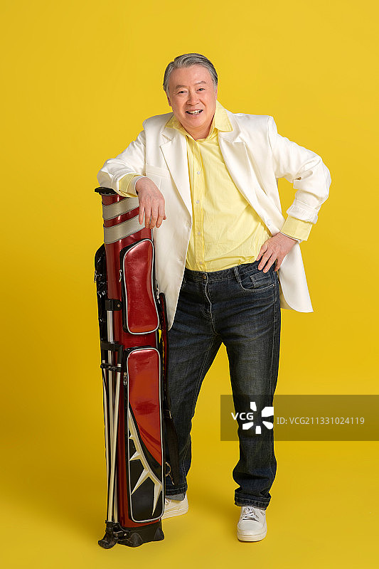 拿着高尔夫球包的快乐老年人图片素材