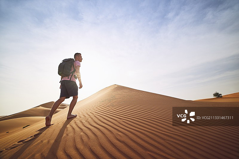 在沙漠的沙丘上奔跑的人图片素材