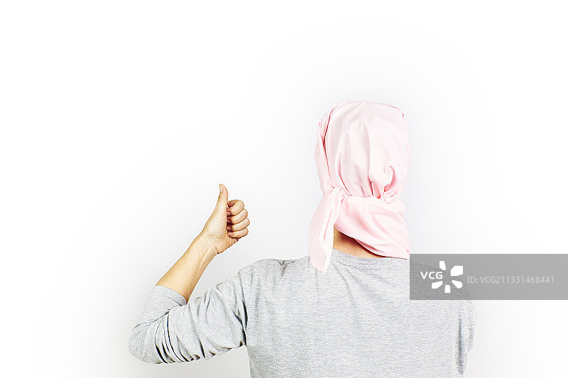 西班牙，一位戴着粉色癌症头巾的妇女举起拇指图片素材
