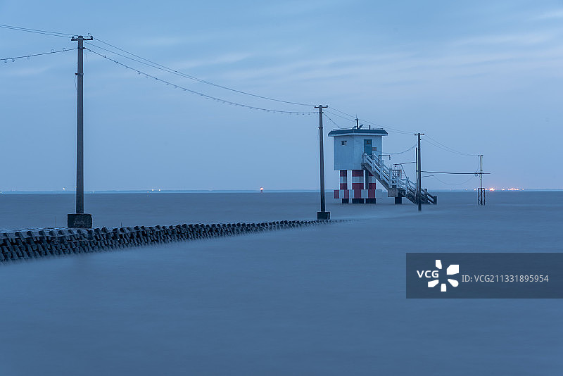 日出时分长江口的横沙岛水文站小屋孤零零地立在汹涌的大海里图片素材