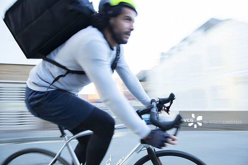 男性自行车快递员在路上超速送餐图片素材