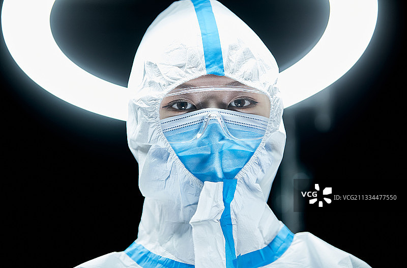 穿白色防护服佩戴护目镜口罩的女性医疗人员图片素材