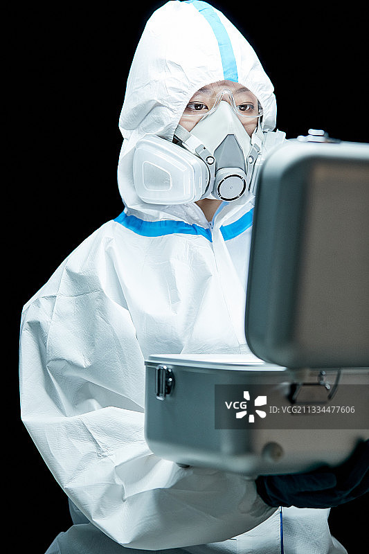 穿白色防护服佩戴护目镜口罩的女性医疗人员图片素材