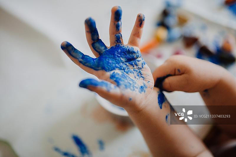 用蓝色颜料裁剪的孩子的手的照片图片素材