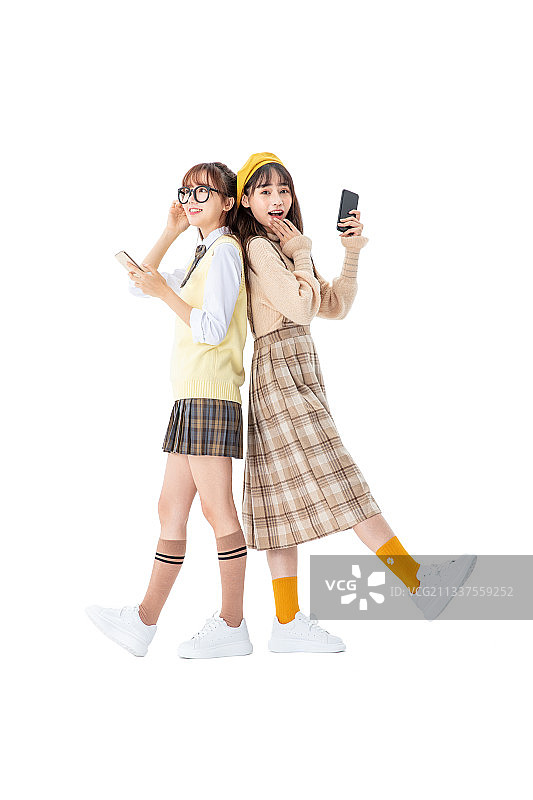 两个女生手拿手机站立图片素材