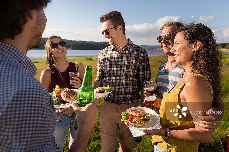 一群朋友，典型的夏季烧烤派对，汉堡和啤酒图片素材