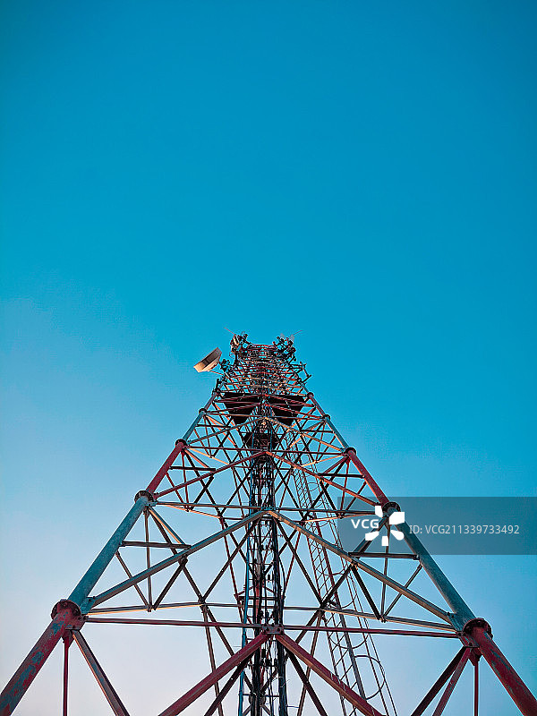 低角度的通信塔对清澈的蓝色天空图片素材