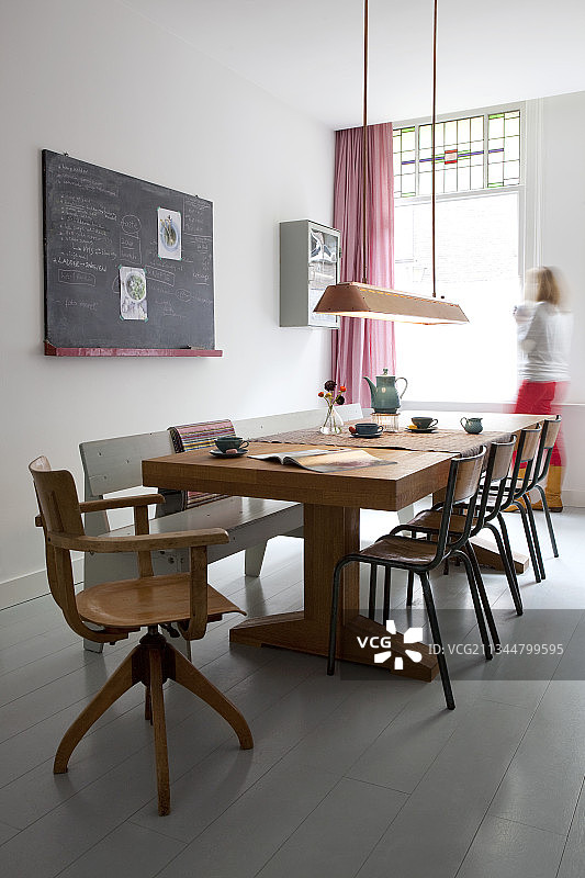 实木餐桌，椅子和长凳旁边的黑板在墙上图片素材