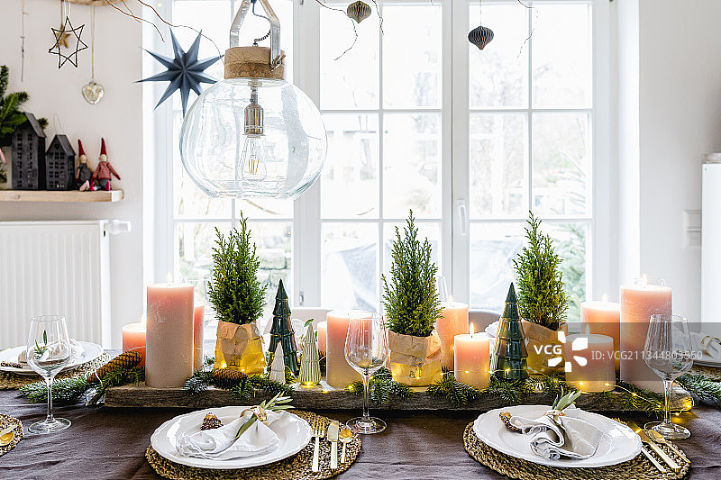 桌子为圣诞节设置了小盆栽松柏和支柱蜡烛图片素材