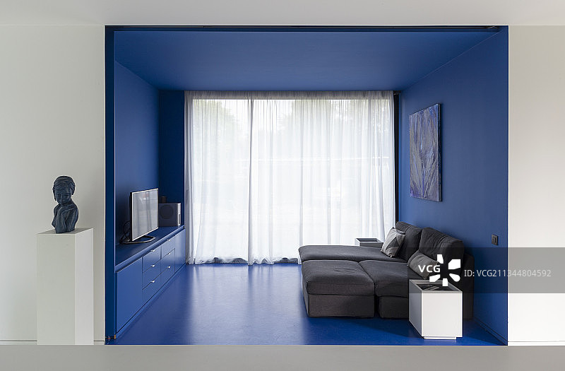 在蓝色凹室的小起居区中，摆放着躺椅图片素材