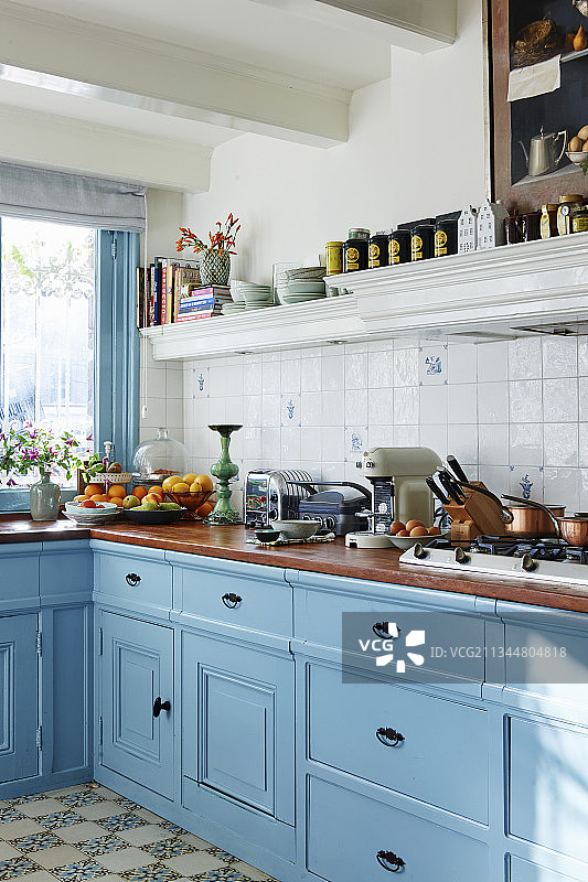 带有浅蓝色镶板橱柜的经典乡村小屋厨房图片素材