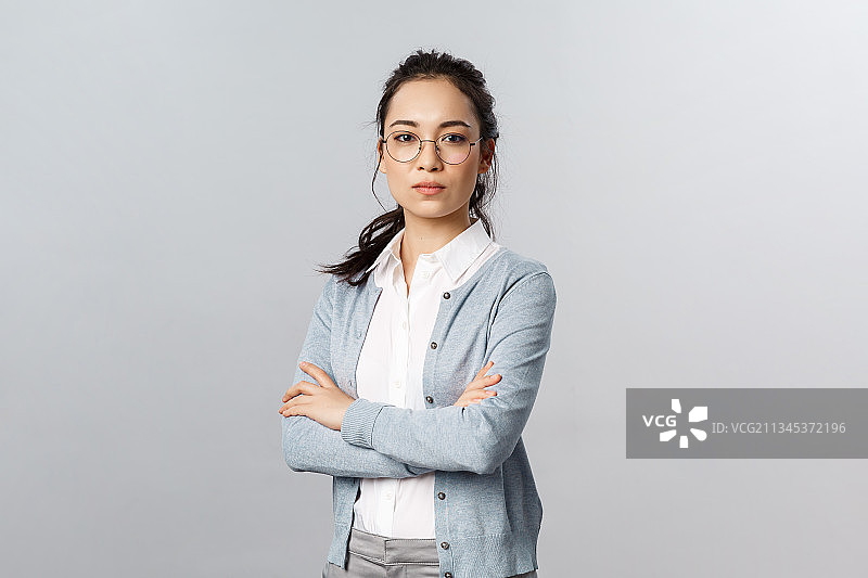 自信的女商人肖像，双臂交叉，站在白色背景下图片素材