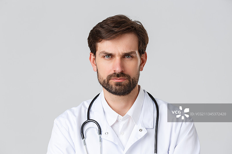 自信的医生在白色背景下的肖像图片素材