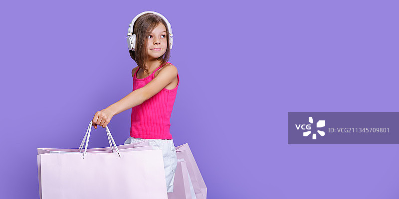 女人拿着购物袋，背景是紫色的图片素材