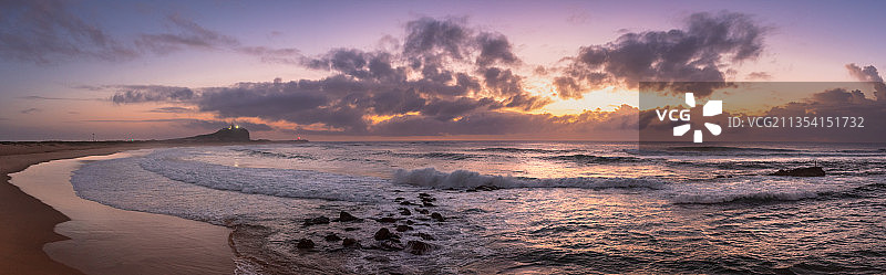 日落时，天空映衬下的海滩风景图片素材