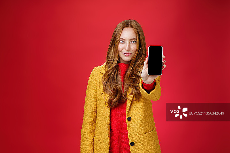 女人的肖像手持手机在红色背景图片素材