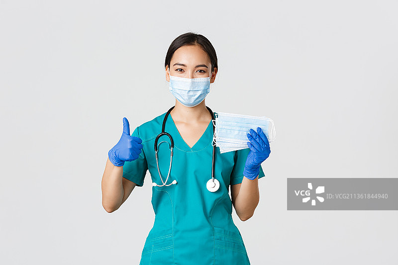 Covid-19，冠状病毒疾病，医务工作者的概念微笑，女医生站在白色背景下打手势的肖像图片素材