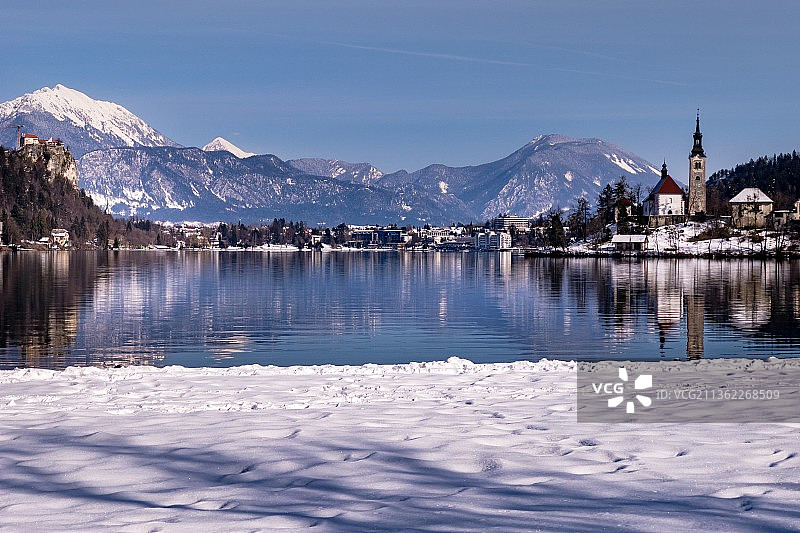 斯洛文尼亚的布莱德湖，在白雪皑皑的山脉映衬下的湖面风景图片素材