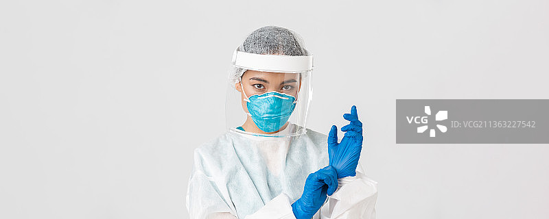 白色背景下手持注射器的女医生的肖像图片素材