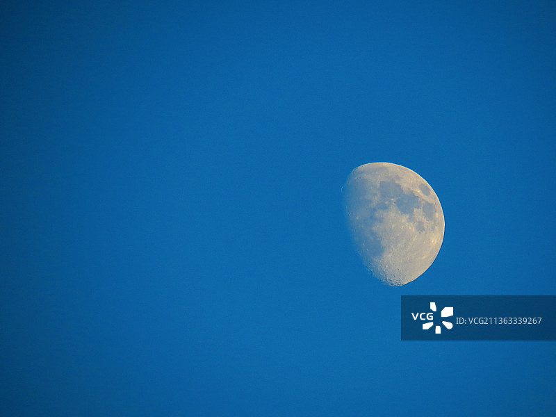 清晰的蓝色天空下的低角度的月亮图片素材