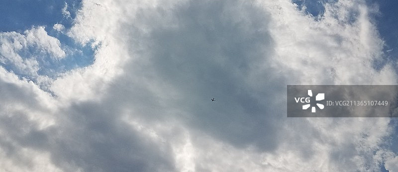 大云与飞机，飞机飞行对多云的天空低角度视图图片素材