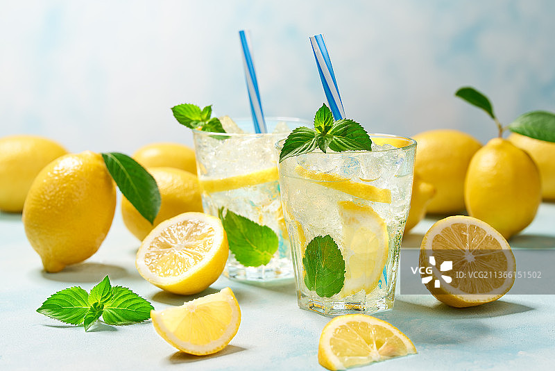 两杯柠檬水，新鲜柠檬，蓝绿色背景图片素材