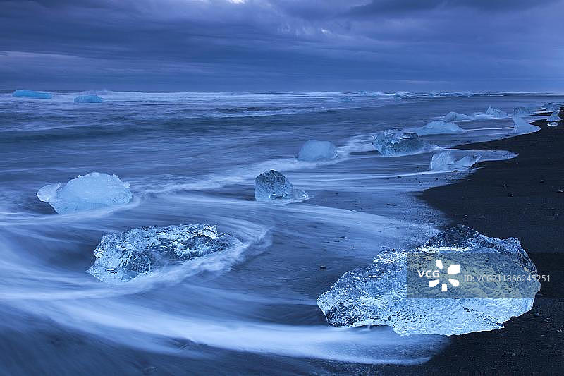 欧洲，冰岛，苏德斯维特，冬季，融化的冰块冲刷着大西洋沿岸的布里德默克桑德尔黑沙海滩图片素材