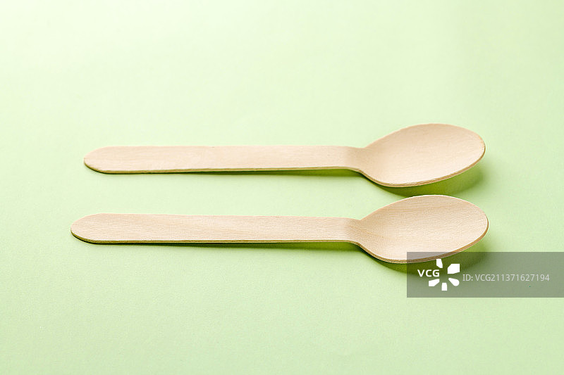 一次性木制餐勺特写绿色莫兰迪色系背景图片素材