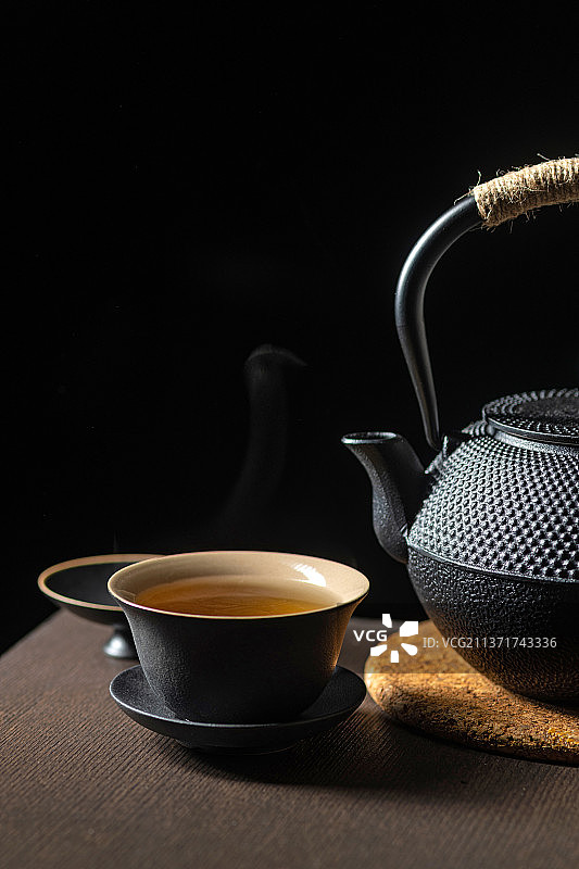 黑陶茶具三才杯盖碗与铁壶摆放在木桌面上深色调图片素材