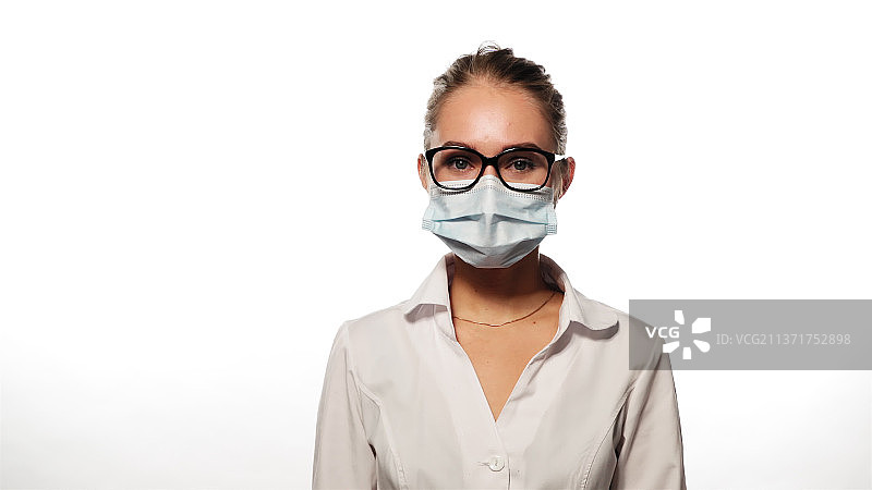 戴着眼镜和医用口罩的年轻护士摇着头听着图片素材