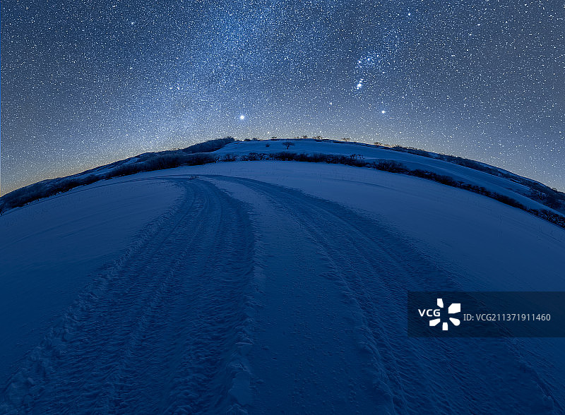 蓝色星空下的雪地车辙印图片素材