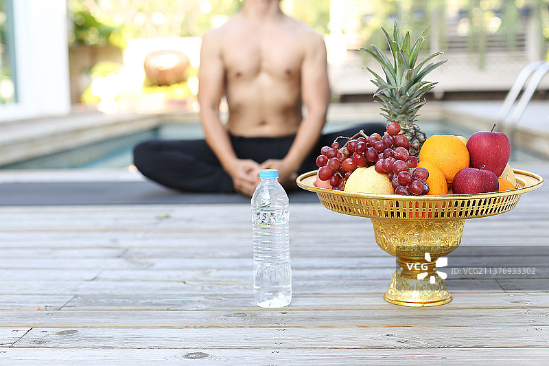 泰国，新鲜水果和瓶装水，男人在做瑜伽图片素材