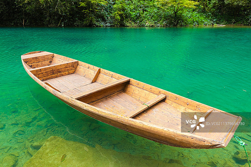 峡谷里一只小木船飘荡在湖面上图片素材