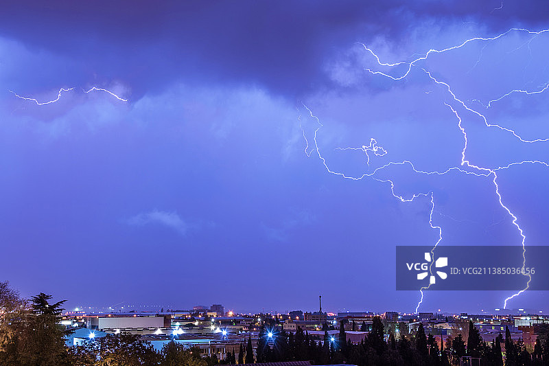 暴风雨之夜，闪电在城市上空的全景图片素材