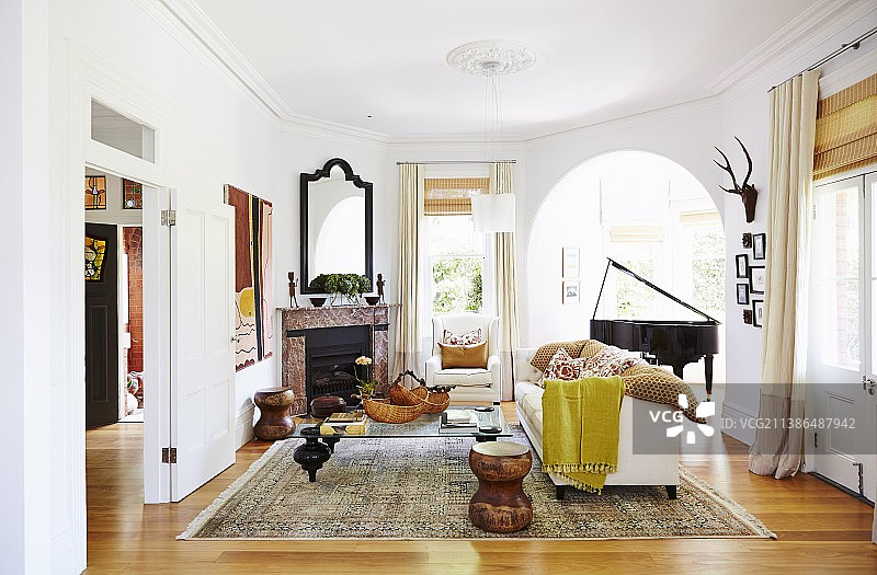 舒适的客厅，有开放式壁炉和一架大钢琴图片素材